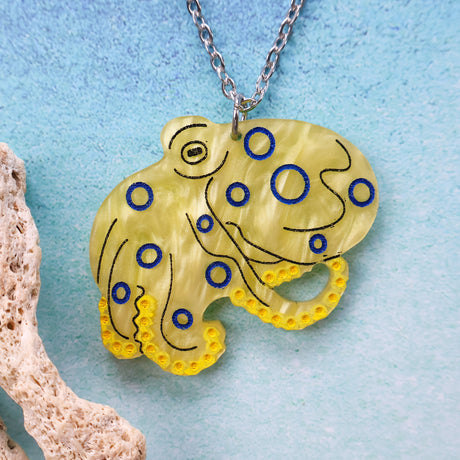 Yellow octopus pendant with blue accents on a chain against a light blue background