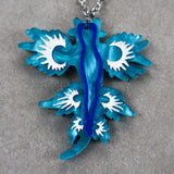 Blue and white sea dragon pendant on a gray background