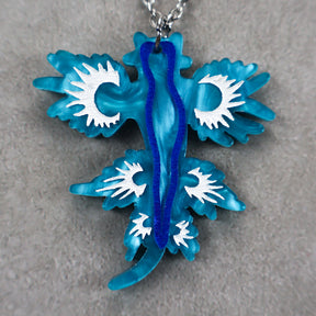 Blue and white sea dragon pendant on a gray background