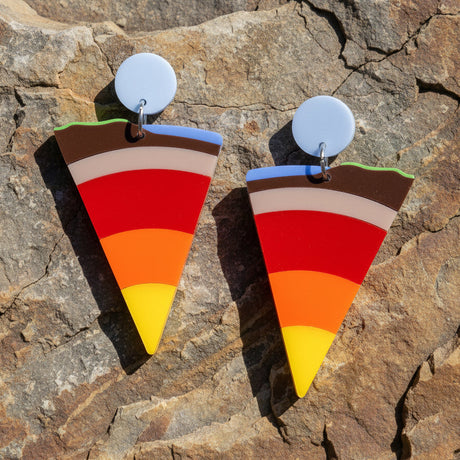 closeup view of wedge shaped earrings representing a cross sectional view through layers of the earth to its core.