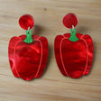 Red pepper or capsicum-shaped marbled acrylic earrings on a light grey background