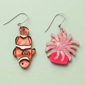 An asymmetrical pair of acrylic earrings with an orange clownfish n one side and a pink sea anemone on the other. Topped with stainless steel french hooks. 