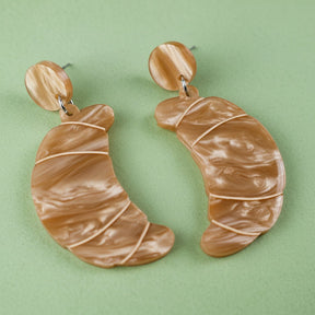 Pair of brown marbled croissant earrings with matching round toppers on a grey background