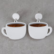 White coffee cup earrings with brown center and white round toppers on a grey background