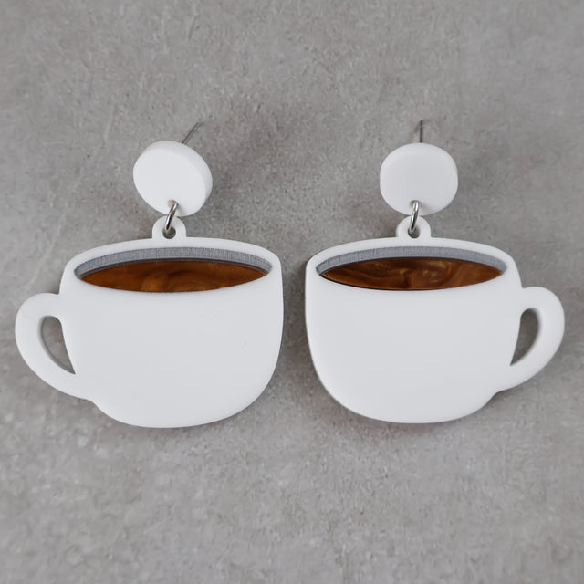 White coffee cup earrings with brown center and white round toppers on a grey background