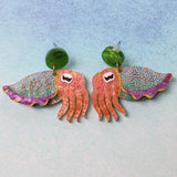Colourful cuttlefish shaped earrings on a light blue background