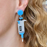 Grey and blue micropipette earrings laser cut and handpainted from acrylic. They hang from blue earring toppers. Earrings are being modelled. 