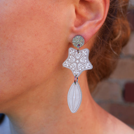 A woman modelling a pair of acrylic Diatom earrings