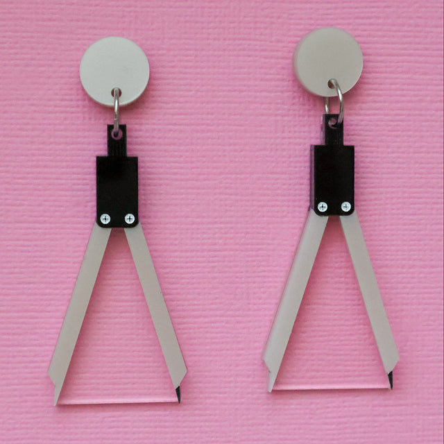A pair of acrylic earrings shaped like a set of drawing compasses.