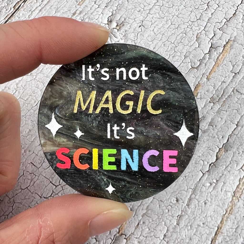 A round brooch with "It's not Magic It's Science' engraved and handpainted within. Made from laser cut swirly acrylic.