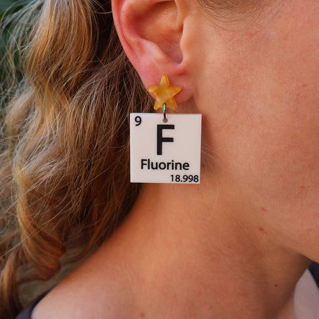Person wearing a 'Fluorine' earring with a star-shaped element
