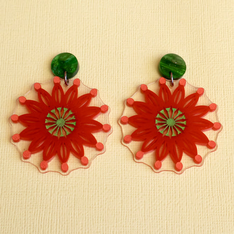Acrylic Firewheel tree earrings closeup. Earrings are red with green round acrylic toppers. 
