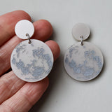 Round earrings with full moon design as seen from southern hemisphere. 