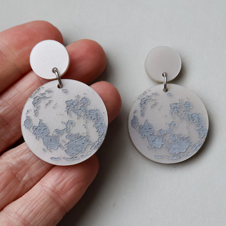 Round earrings with full moon design as seen from southern hemisphere. 