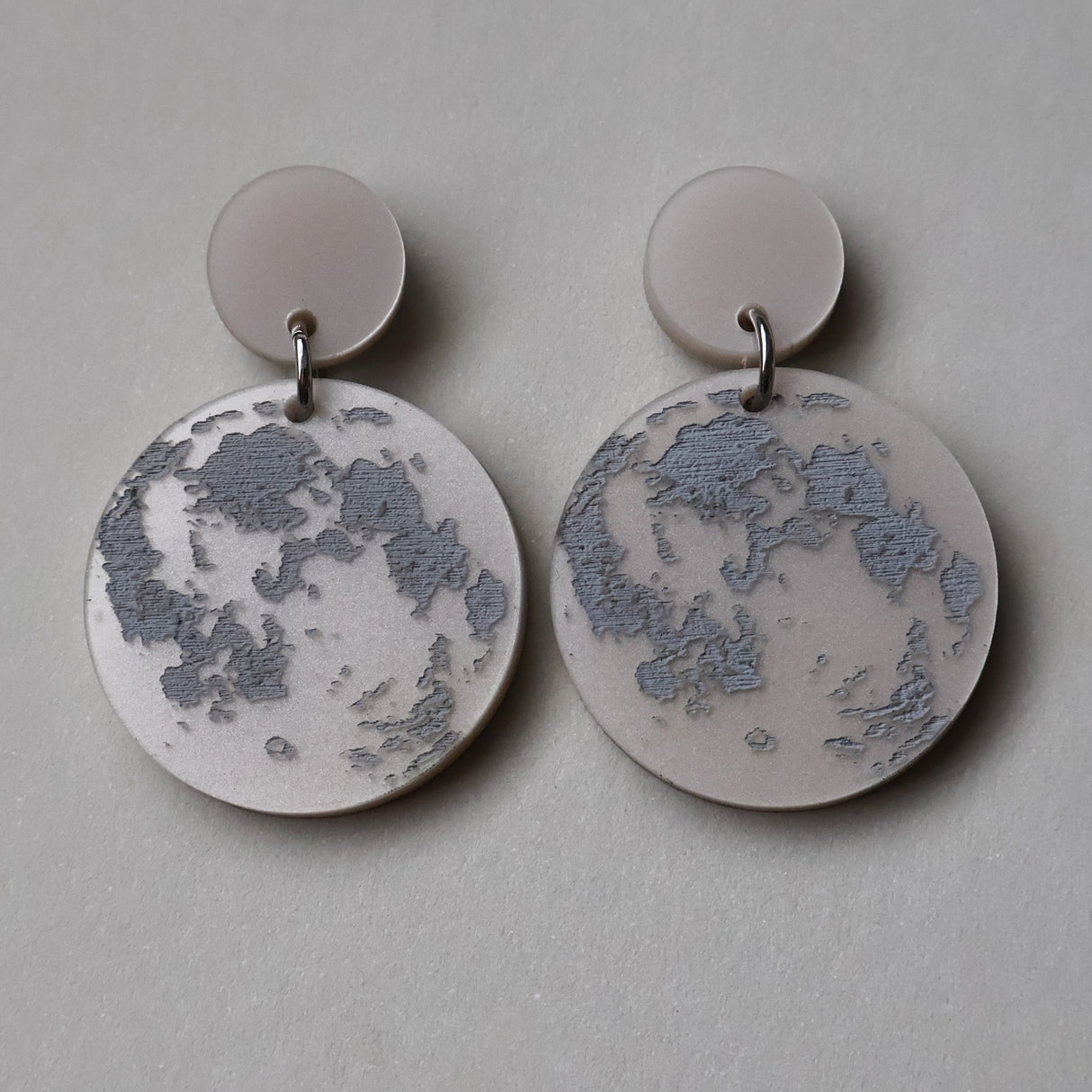 Pair of earrings with full moon designs as seen from the northern hemisphere. 