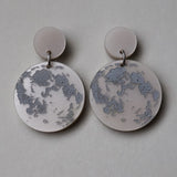 Pair of earrings with full moon designs as seen from the northern hemisphere. 
