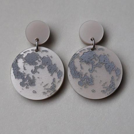 Pair of earrings with full moon designs as seen from the northern hemisphere. 