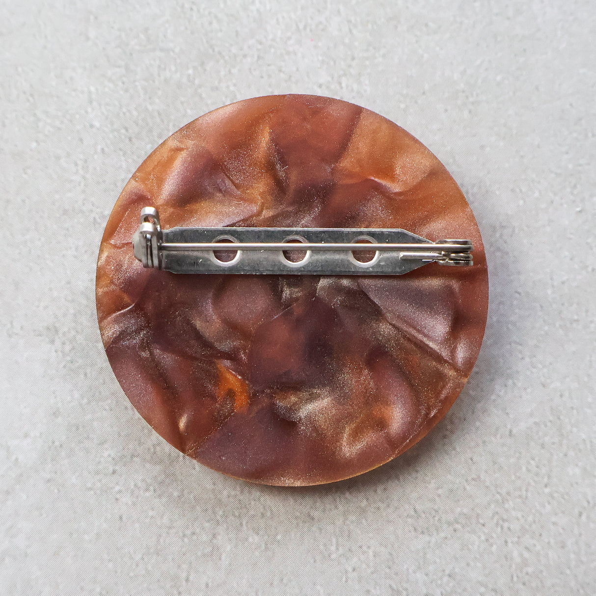 Round brown brooch back with a stainless steel brooch in and locking clasp