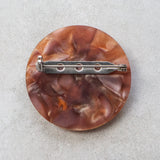 Round brown brooch back with a stainless steel brooch in and locking clasp