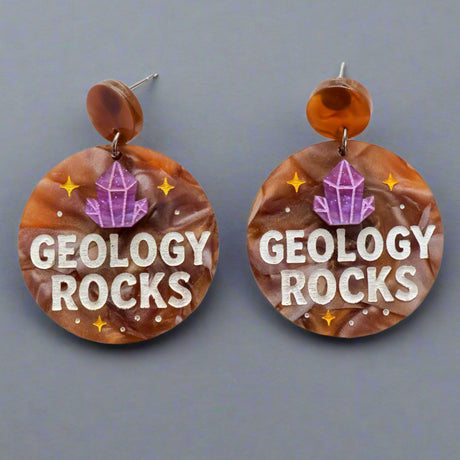 Earrings with 'Geology Rocks' text and a crystal design on a gray background