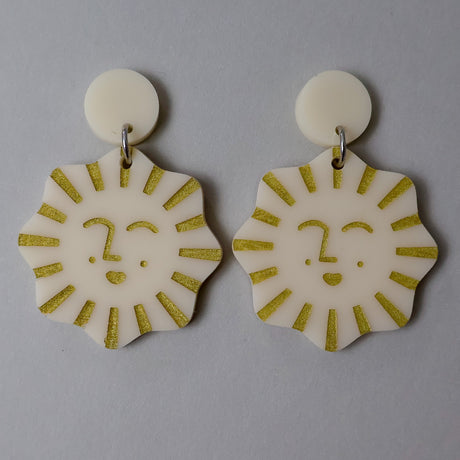 Pair of tan and gold acrylic earrings with smiling sun design 