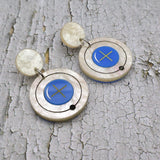 Closeup view of hydrogen atom dangle earrings made from laser cut acrylic. 