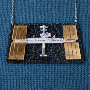 Statement acrylic necklace depicting the international space station, with stainless steel chain. 