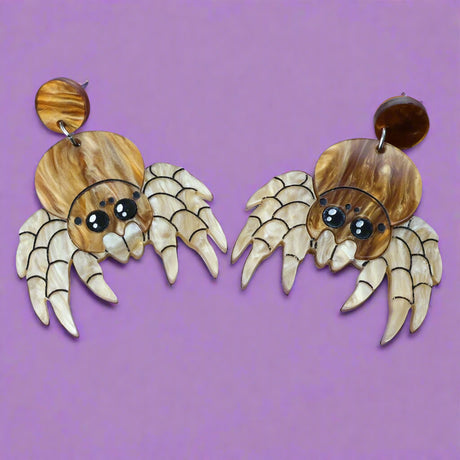 Laser cut acrylic jumping spider dangle earrings, closeup.