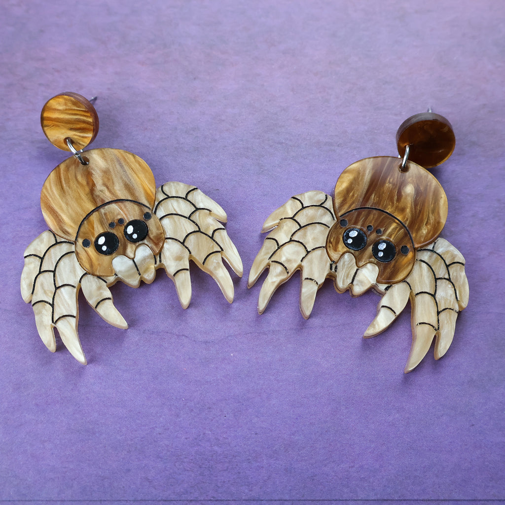 Laser cut acrylic jumping spider earrings, closeup.