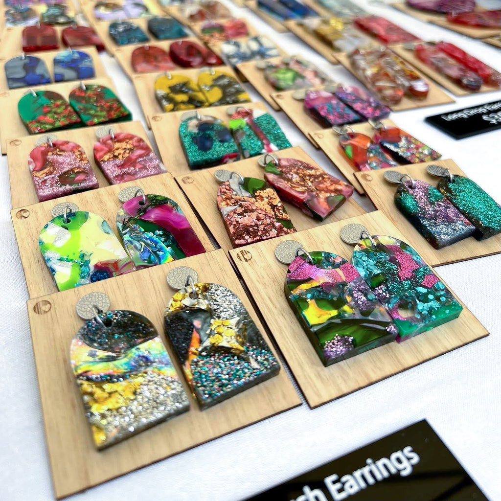 Lots of recycled earrings laid out on the table at a market stall. 