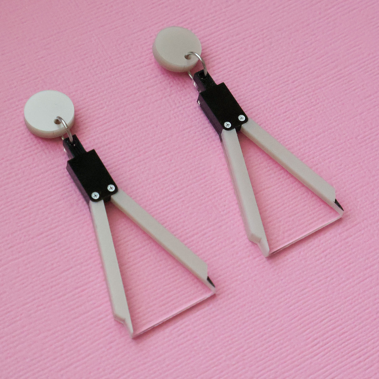 Pair of Math Compass acrylic on a pink textured background