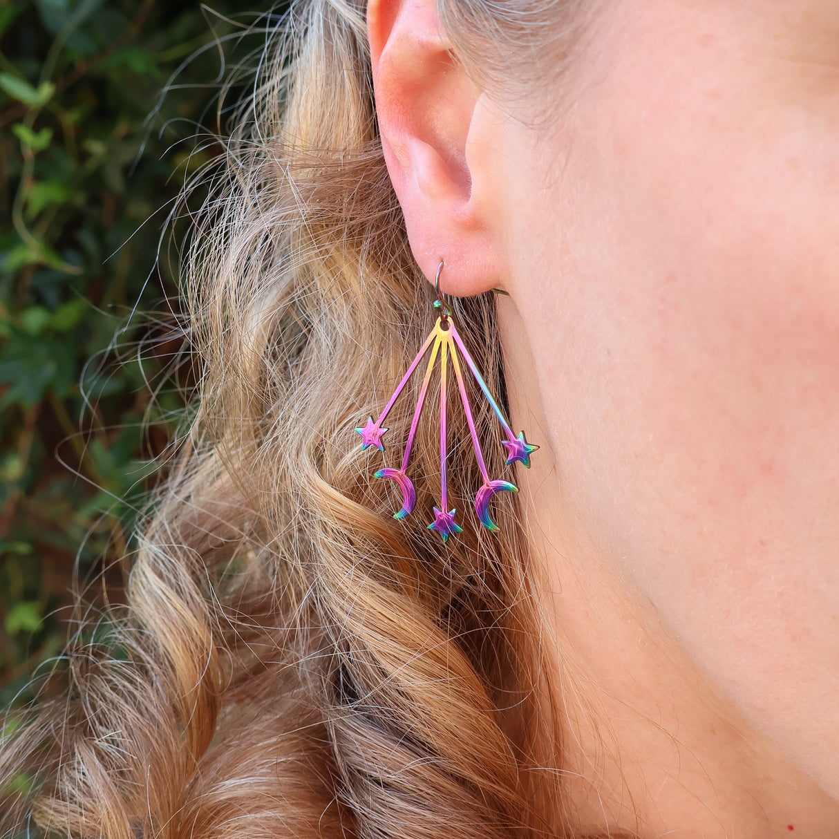 Moon and star stainless steel rainbow earrings being modelled