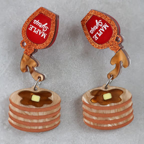 Earrings with pancake and syrup design on a gray background