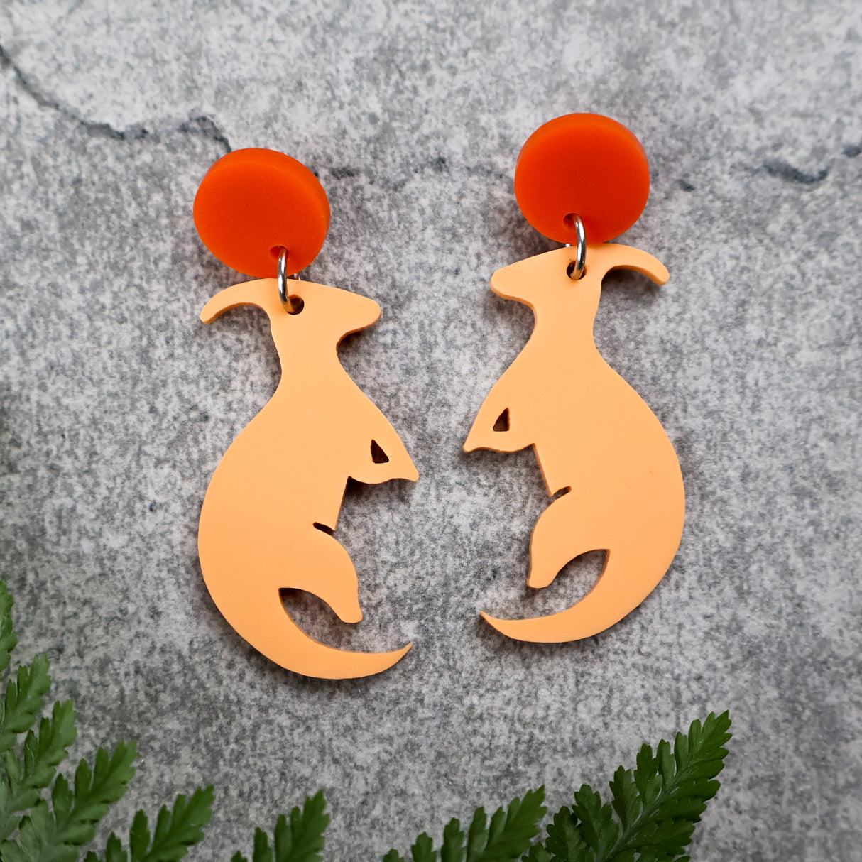 Orange parasaurolophus dangle earrings with darker orange toppers. Made from laser cut acrylic. 