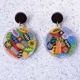 Round earrings resembling Petri Dishes with colourful acrylic shapes arranged within and black acrylic toppers. 