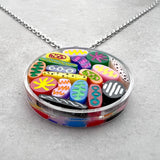 Necklace with colorful Petri dish acrylic pendant on a gray background