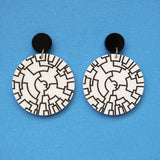 Pair of round acrylic earrings with black and white phylogenetic tree pattern on a blue background