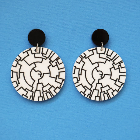 Pair of round acrylic earrings with black and white phylogenetic tree pattern on a blue background