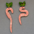 Pair of worm-shaped earrings with green leaf toppers on a grey background