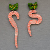 Pair of worm-shaped earrings with green leaf toppers on a grey background