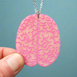 Pink brain-shaped pendant held by a hand with stainless steel chain