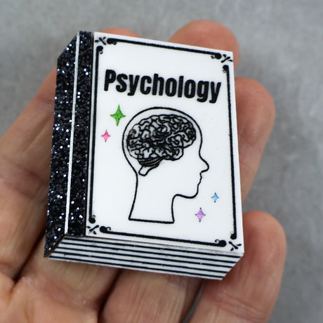 Book acrylic labeled 'Psychology' held in a hand