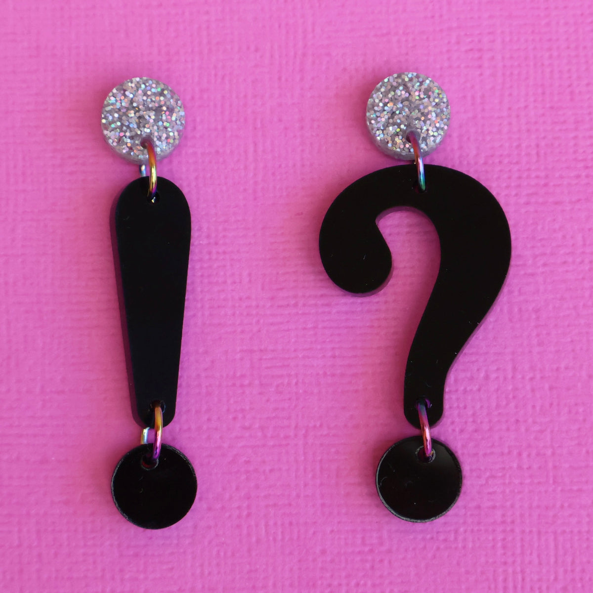 Asymmetrical punctuation mark earrings in hand showing a question and exclamation mark