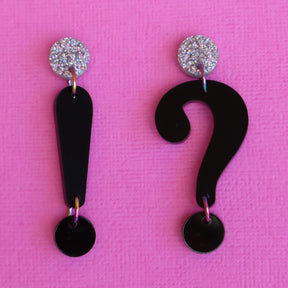 Asymmetrical punctuation mark earrings in hand showing a question and exclamation mark