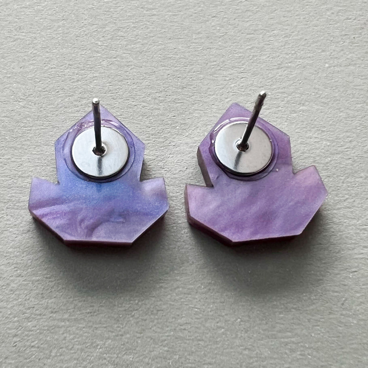 Back view of a pair of purple acrylic studs showing stainless steel posts