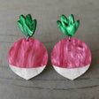 Radish earrings with a pink and white marbled acrylic bodies and green marbled toppers. 