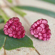 Pink marbled acrylic raspberry-shaped earrings on a grey background