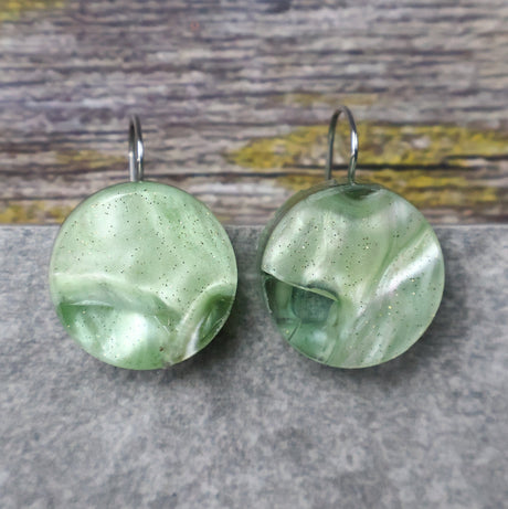 A pair of one of a kind round recycled acrylic earrings with stainless steel french hooks and green acrylics titled  'Green Ripple'. 