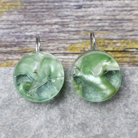 A pair of one of a kind round recycled acrylic earrings with stainless steel french hooks and green acrylics titled  'Green Ripple'.  