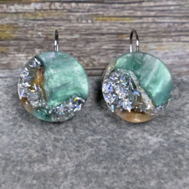 A pair of one of a kind round recycled acrylic earrings with stainless steel french hooks and silver, green and brown design titled 'Celestial Tide' Pair 106-14